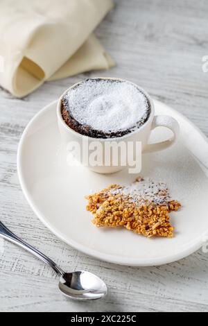 Schokoladensoufflé mit fließender Schokolade auf einem weißen Porzellanteller Stockfoto