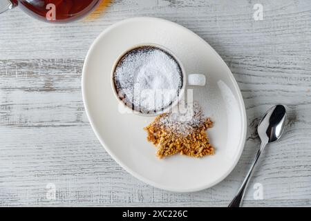 Schokoladensoufflé mit fließender Schokolade auf einem weißen Porzellanteller Stockfoto