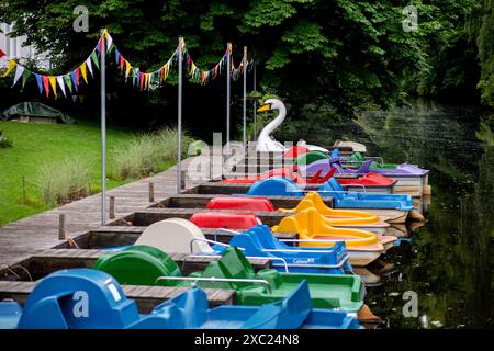 Oldenburg, Deutschland. Juni 2024. Zahlreiche bunte Tretboote liegen auf einem Holzsteg an der Mühlenhunte im Stadtzentrum vor. Der Deutsche Wetterdienst prognostiziert für die nächsten Tage weitere Wetterschwankungen in Niedersachsen und Bremen. Quelle: Hauke-Christian Dittrich/dpa/Alamy Live News Stockfoto