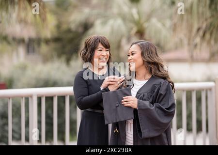 Mutter lacht mit Tochter am Abschlussfeiertag Stockfoto