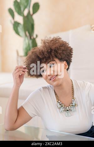Frauen mit lockigem Afro sitzen auf der Seite mit dem Pakt Stockfoto