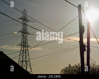 Ich liebe Strommasten; ich finde ihre abstrakten, hageren Formen unendlich faszinierend. Hier sehen wir einen in den Feldern in Lower Radley, beleuchtet vom gl Stockfoto