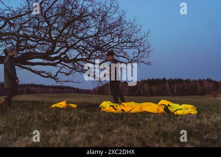 Ein Mann baut ein Zelt auf einem Campingausflug im Wald. Stockfoto