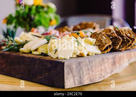 Exquisite Käseplatte mit Crackern und frischen Kräutern Stockfoto