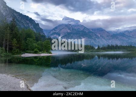 Dieses atemberaubende Bild fängt die Schönheit des Almsees in Österreich ein. Das ruhige Wasser reflektiert die umliegenden Berggipfel und schafft ein atemberaubendes sce Stockfoto