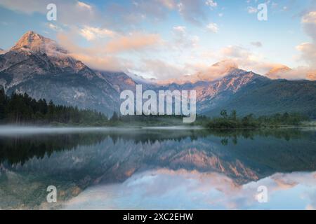 Dieses atemberaubende Bild fängt die Schönheit des Almsees in Österreich ein. Das ruhige Wasser reflektiert die umliegenden Berggipfel und schafft ein atemberaubendes sce Stockfoto