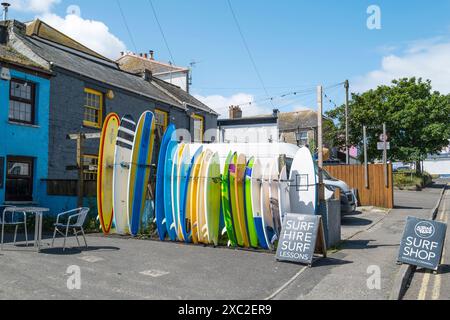 Surfbretter stapeln sich vor einem Surfverleihladen Newquay Town Centre in Cornwall, Großbritannien. Stockfoto