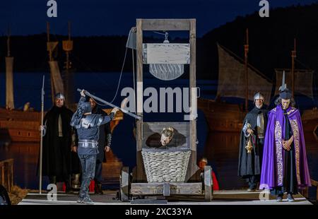 Stoertebeker Festspiele 2024 die Schauspieler Moritz Stephan M. als Klaus Stoertebekerliegt unter dem Fallbeil in einer Szene der Stoertebeker-Festspiele. Das Theaterstueck ÂHamburg 1401Â mit den legendaeren Piraten Klaus Stoertebeker und Goedeke Michels hat am 15. Juni 2024 Premiere auf der Insel Rügen. Die Stoertebeker-Festspiele werden bis zum 31. August 2024 auf der Naturbühne in Ralswiek gezeigt. Ralswiek Mecklenburg-Vorpommern Deutschland *** Stoertebeker Festival 2024 der Schauspieler Moritz Stephan M als Klaus Stoertebeker liegt unter der Guillotine in einer Szene des Stoertebeker Festivals Stockfoto