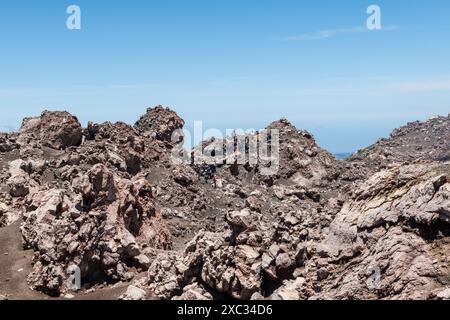 Eine Gruppe von Wanderern in der wilden und surrealen Vulkanlandschaft auf 3200 m in der Nähe des Gipfels des Ätna, Europas aktivstem Vulkan (Sizilien, Italien) Stockfoto