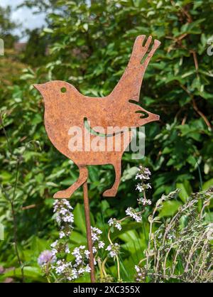 Garten Metalldekor Vogel in einem üppigen Frühlingsgarten Stockfoto