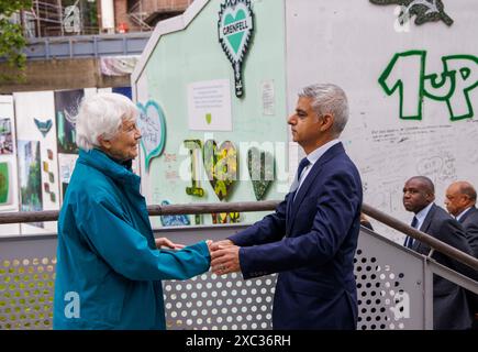 London, Großbritannien. Juni 2024. Der Bürgermeister von London, Sadiq Khan, trifft einen Einheimischen. Das Feuer im Grenfell Tower ereignete sich heute vor genau sieben Jahren. Die Menschen erweisen Respekt und hinterlassen florale Tribut. Heute Abend wird es einen stillen Spaziergang geben, um an die zu erinnern, die im Feuer gestorben sind. Quelle: Mark Thomas/Alamy Live News Stockfoto