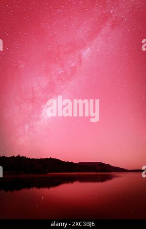 Die Milchstraße und eine aurora erleuchten den Nachthimmel über dem Lake Tarawera, Neuseeland, während eines Sonnensturms Stockfoto
