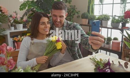 Mann und Frau Floristen machen ein Selfie mit einem Smartphone in einem Blumenladen mit Pflanzen. Stockfoto