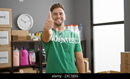 Ein hübscher junger hispanischer Mann mit einem Bart, der in einem Lagerhaus die Daumen hochlegt Stockfoto