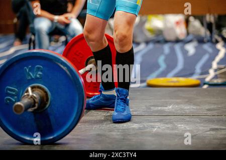 Beinfrau Athletin in schwarzen Kniestrümpfen in der Nähe der Langhantel-Deadlift Stockfoto