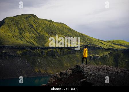 Dieses Foto zeigt ein Backpacker Mädchen, das den Blick auf den Blahylur See in Island genießt. Sie steht am Ufer des Sees und blickt auf die Umgebung Stockfoto