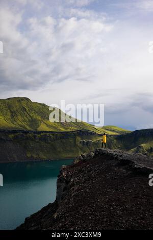 Dieses Foto zeigt ein Backpacker Mädchen, das die Schönheit des Blahylur Lake in Island betrachtet. Sie steht mit der Seite zur Kamera, ein Bein nach vorne, Stockfoto