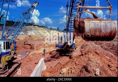 Suriname – Bagger in der Bauxitmine füllen einen Lkw mit Bauxieterz. Eine Fabrik wird Bauxiterz extrahieren, um Aluminium zu produzieren. Stockfoto