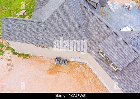 Das Baudach des neuen Hauses ist mit Gummiasphaltdach-Dachschindeln abgedeckt Stockfoto