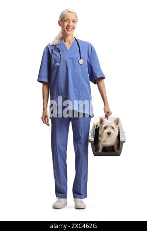 Tierärztin in blauer Uniform, die eine Haustiertrage mit einem Hund auf weißem Hintergrund hält Stockfoto