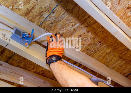 Ein Elektriker installiert LED-Deckeneinbauleuchten in einem neuen Zuhause Stockfoto