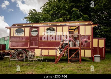 jon Cheese sitzt auf den Stufen seines restaurierten Showman Carriage aus den 1930er Jahren, der einst mit Entertainern und Zirkuskünstlern durch Großbritannien reiste, um sich auf das Wochenende High Weald Steam Working Weekend, Pippingford Park Nutley, East Sussex, UK, vorzubereiten Stockfoto