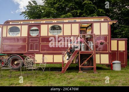 Jon Cheese sitzt auf den Stufen seines restaurierten Showman Carriage aus den 1930er Jahren, der einst mit Entertainern und Zirkuskünstlern durch Großbritannien reiste, um sich auf das Wochenende High Weald Steam Working Weekend, Pippingford Park Nutley, East Sussex, UK, vorzubereiten Stockfoto