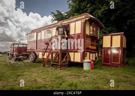 Jon Cheese sitzt auf den Stufen seines restaurierten Showman Carriage aus den 1930er Jahren, der einst mit Entertainern und Zirkuskünstlern durch Großbritannien reiste, um sich auf das Wochenende High Weald Steam Working Weekend, Pippingford Park Nutley, East Sussex, UK, vorzubereiten Stockfoto