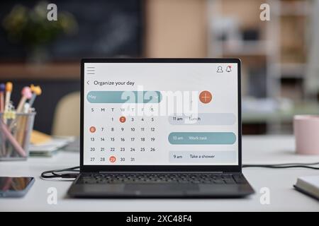Nahaufnahme eines Laptops auf dem Schreibtisch im Klassenzimmer mit Kalenderseite und Kopierraum Stockfoto