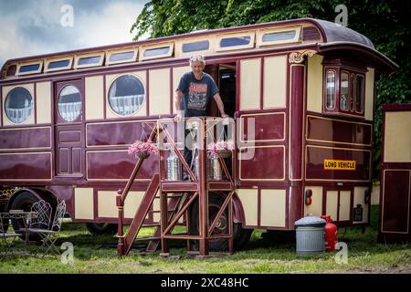 Jon Cheese sitzt auf den Stufen seines restaurierten Showman Carriage aus den 1930er Jahren, der einst mit Entertainern und Zirkuskünstlern durch Großbritannien reiste, um sich auf das Wochenende High Weald Steam Working Weekend, Pippingford Park Nutley, East Sussex, UK, vorzubereiten Stockfoto