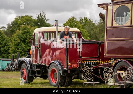 Jon Cheese sitzt in seinem 1950er Jahre Scammell Truck, der einen restaurierten Showmans Living Carriageage zog, der einst mit Entertainern und Zirkuskünstlern durch Großbritannien reiste, um sich auf das Wochenende High Weald Steam Working Weekend vorzubereiten, Pippingford Park Nutley, East Sussex, Großbritannien Stockfoto