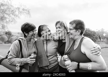 Fröhliche, multiethnische Seniorinnen, die nach dem Training im Park Spaß haben Stockfoto