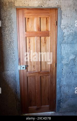 Holztür in Betonwand, Hintergrund, Vorderansicht Stockfoto
