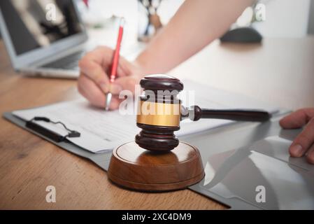 Anwalt oder Anwalt, der Dokumente schreibt. Holzhammer auf dem Tisch Stockfoto