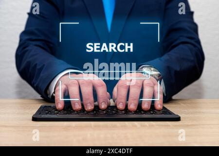 Ein nicht erkennbarer Mann in einem blauen Anzug tippt auf einer Tastatur mit dem Wort Suche auf dem Bildschirm. Stockfoto