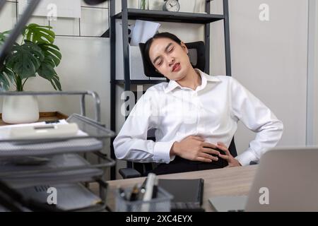 Geschäftsfrau mit Menstruationsschmerzen bei der Arbeit, Büro Stress, weibliche Gesundheit Probleme, professionelle Frau in Unannehmlichkeiten, Arbeitsplatz Herausforderungen Stockfoto