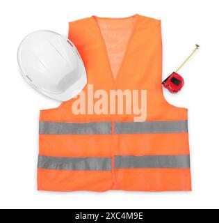 Orangefarbene reflektierende Weste, Schutzhelm und Bandmaß isoliert auf weiß, Draufsicht Stockfoto