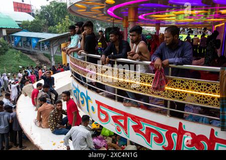 14. Juni 2024, Dhaka, Dhaka, Bangladesch: Die Urlauber versammeln sich auf dem Dach der überfüllten Fähren, um mit ihren Familien vor dem größten muslimischen Festival Eid al-Adha am Sadarghat Launch Terminal in Dhaka, Bangladesch, zusammen zu sein. Tausende von Dhaka-Stadtbewohnern begannen, die Stadt in ihre Heimatstadt zu verlassen, um das Festival zu feiern. Dieser verzweifelte Versuch, sich mit der Familie wieder zu vereinen, unterstreicht den Druck auf die Verkehrsinfrastruktur während der großen Feiertage. Das Phänomen wird durch die beträchtliche Migration nach Dhaka, wo, noch verstärkt Stockfoto