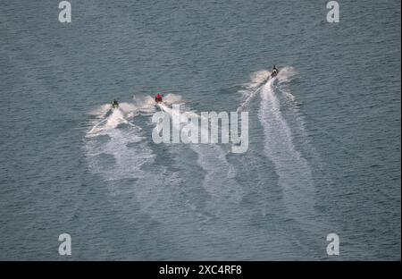 Ultrabreites Foto der Luftdrohne von Jet-Ski-Wasserfahrzeugen, die in hoher Geschwindigkeit im Yachthafen von lusail fahren Stockfoto