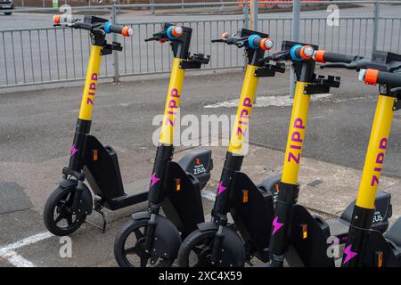 Slough, Großbritannien. Juni 2024. Trial Zipp E-Scooter zur Vermietung in Slough, Berkshire. Der Stadtrat von Slough hat angekündigt, dass Personen, die E-Scooter in Slough mieten, während der UEFA Euro 2024 von den reduzierten Mietpreisen für E-Scooter profitieren werden. Einige Bewohner befürchten, dass dies bedeuten könnte, dass Fußballfans, die ihre Autos zu Hause lassen, um die Spiele im Pub zu sehen, dann E-Scooter mieten könnten, um sie nach Hause zu bringen, während sie unter Alkoholeinfluss stehen. Das Gesetz sieht vor, dass „Sie keinen E-Roller fahren sollten, während Sie betrunken oder anderweitig betrunken sind – Sie können strafrechtlich verfolgt werden Stockfoto