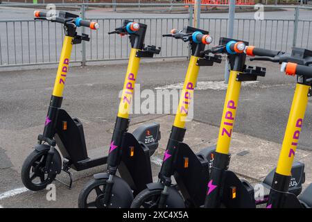 Slough, Großbritannien. Juni 2024. Trial Zipp E-Scooter zur Vermietung in Slough, Berkshire. Der Stadtrat von Slough hat angekündigt, dass Personen, die E-Scooter in Slough mieten, während der UEFA Euro 2024 von den reduzierten Mietpreisen für E-Scooter profitieren werden. Einige Bewohner befürchten, dass dies bedeuten könnte, dass Fußballfans, die ihre Autos zu Hause lassen, um die Spiele im Pub zu sehen, dann E-Scooter mieten könnten, um sie nach Hause zu bringen, während sie unter Alkoholeinfluss stehen. Das Gesetz sieht vor, dass „Sie keinen E-Roller fahren sollten, während Sie betrunken oder anderweitig betrunken sind – Sie können strafrechtlich verfolgt werden Stockfoto