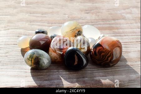 Heilkristalle auf einem alten hölzernen Hintergrund. Botswana-Achat. Mehrfarbige Edelsteine, Mineralien. Achate unterschiedlicher Größe. Stockfoto