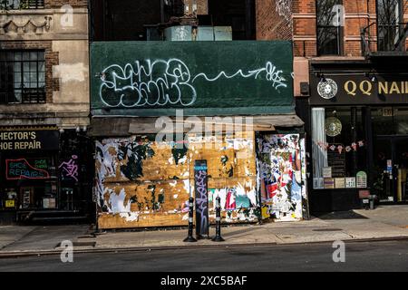 Verlassenes Geschäft auf der Greenwich Avenue, bedeckt mit zerrissenen Plakaten und Graffitis in Greenwich Village, Manhattan, New York City, NY, USA Stockfoto