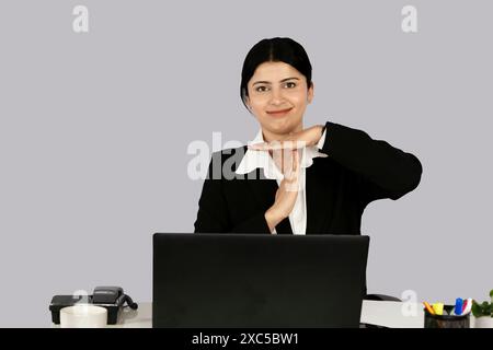 Wunderschöner asiatisch-indischer Receptinist Unternehmer mit Laptop, Kopfhörer und Tagebuch gibt Gesten und Ausdrücke Stockfoto