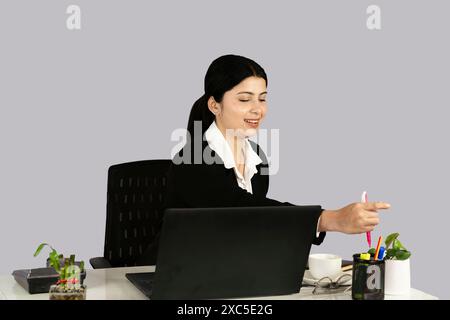 Wunderschöner asiatisch-indischer Receptinist Unternehmer mit Laptop, Kopfhörer und Tagebuch gibt Gesten und Ausdrücke Stockfoto