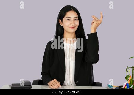 Wunderschöner asiatisch-indischer Receptinist Unternehmer mit Laptop, Kopfhörer und Tagebuch gibt Gesten und Ausdrücke Stockfoto