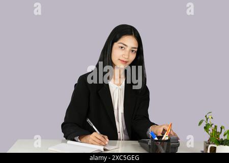 Wunderschöner asiatisch-indischer Receptinist Unternehmer mit Laptop, Kopfhörer und Tagebuch gibt Gesten und Ausdrücke Stockfoto