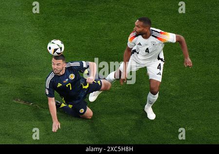 Der schottische John McGinn (links) und der deutsche Jonathan Tah kämpfen während des Gruppenspiels der UEFA Euro 2024 in der Münchener Football Arena um den Ball. Bilddatum: Freitag, 14. Juni 2024. Stockfoto