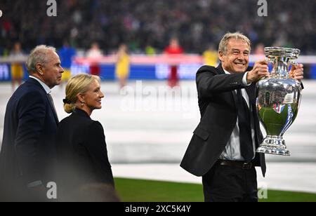 München, Deutschland. Juni 2024. Fußball, UEFA Euro 2024, Europameisterschaft, Deutschland - Schottland, Vorrunde, Gruppe A, Spieltag 1, Fußballarena München, Heidi Beckenbauer (M), Witwe des ehemaligen Nationalspielers und Trainers Franz Beckenbauer, steht mit Bernard Dietz (l) und Jürgen Klinsmann, den deutschen Kapitänen bei den Europameisterschaften 1980 und 1996, während Klinsmann die Europameisterschaft-Trophäe hält. Quelle: Tom Weller/dpa/Alamy Live News Stockfoto