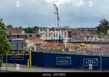 Slough, Großbritannien. Juni 2024. Bellway Homes haben mit dem Bau einer neuen Entwicklung von Wohnungen und 3-Zimmer-Häusern auf dem Gelände des ehemaligen Magnet Lesiure Centre in Slough, Berkshire begonnen. Der Standort wurde während der COVID-19-Pandemie als riesiger COVID-19-Teststandort genutzt. Der heute Montem Square heißt, überblickt den berühmten Montem Mound (im Bild), der ein geplantes antikes Monument ist. Die Häuser haben auch einen Blick auf Windsor Castle. In Slough wird viel gebaut, da es an der Elizabeth Line nach London liegt. Kredit: Maureen McLean/Alamy Stockfoto